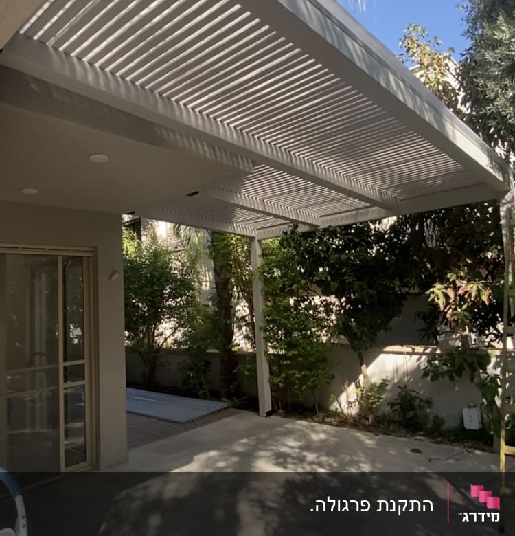 פרגולה לבנה עם צללים על הרצפה בגינה